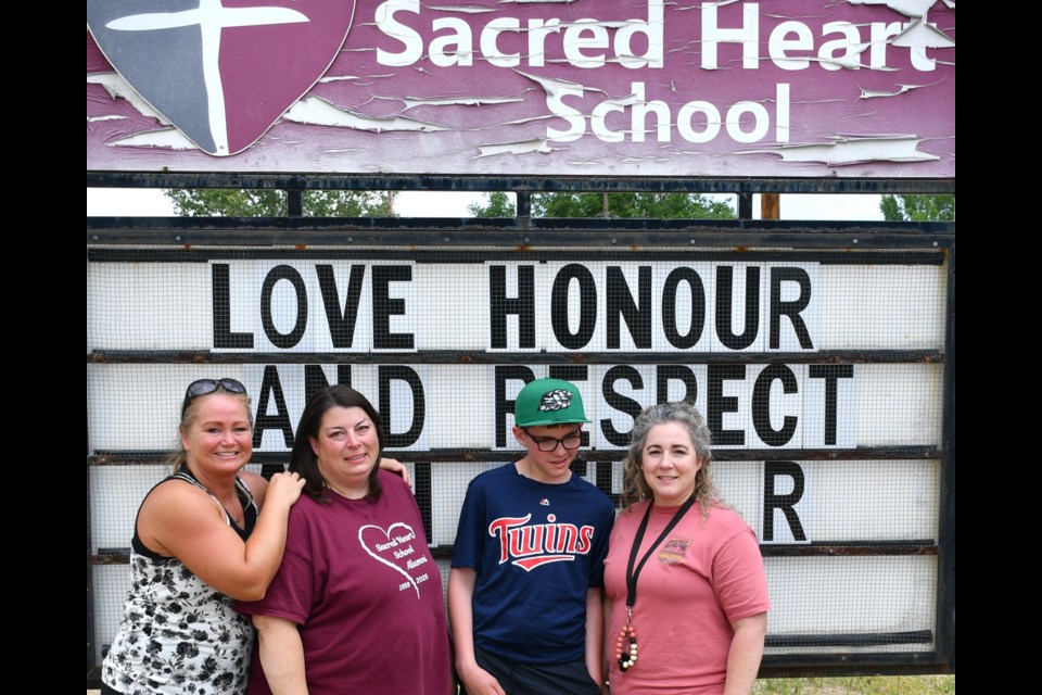 Left to right: Tara Cathcart, Susan Umana, Rhyley, and Jocelynn Steeves stand in front of Sacred Heart School before its doors close one last time.