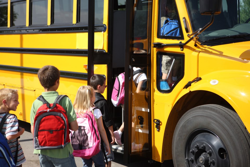students getting on school bus shutterstock