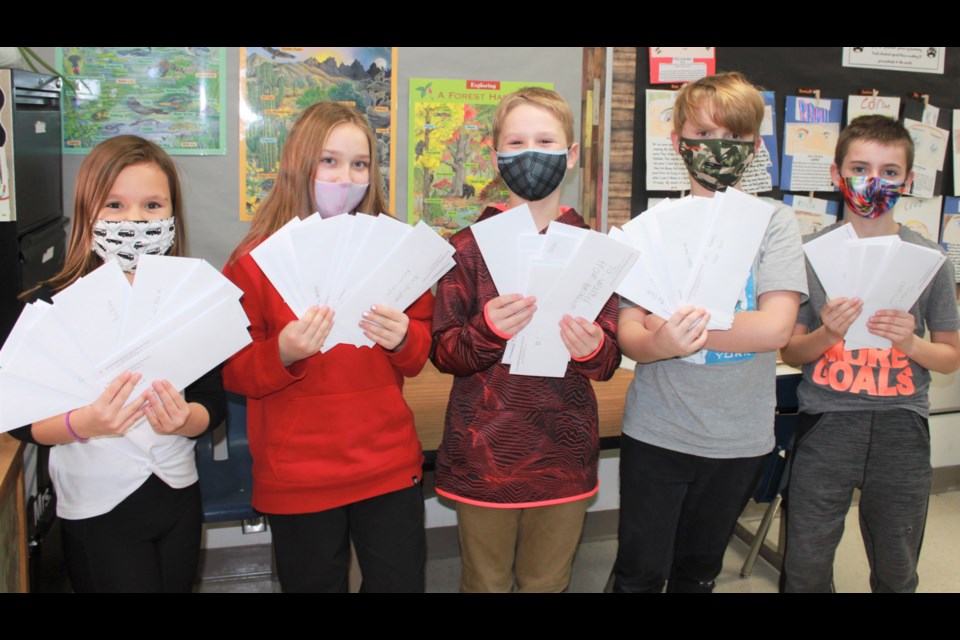 A group of Grade 4 students from Sunningdale School shows the volume of letters they wrote to seniors at Chateau St. Michael's nursing home. From left are Kenzie, Scout, Cruz, Knox, and James. Photo courtesy Krista Bakken