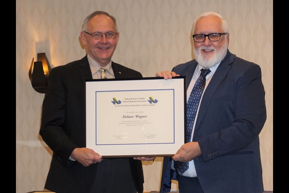Jerome Niezgoda, president of the Saskatchewan Catholic School Boards Association (left) presents the Julian Paslawski Meritorious Service Award to Delmer Wagner for his work in Catholic education over 30 years. Wagner spent most of his career with Holy Trinity School Division. Photo submitted                               