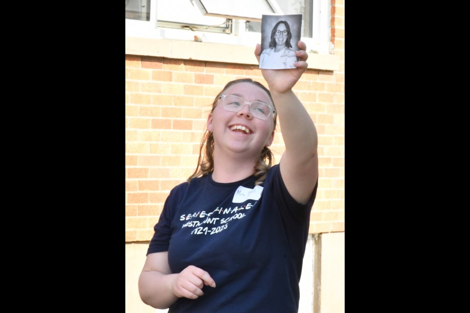 Olivia Doll, an educational assistant, holds up a picture of a teacher during a game of bingo. Photo by Jason G. Antonio