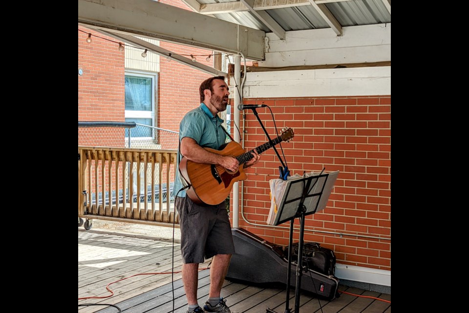 Brent Meidinger singing for the residents while playing guitar