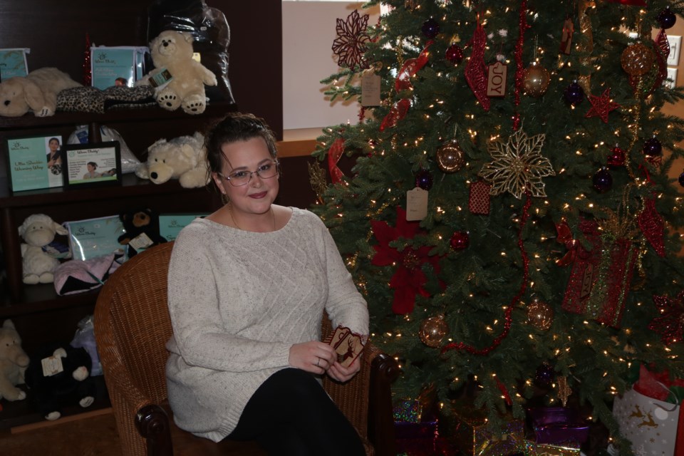 Ashley Armstrong shows the Christmas tree and tags for Christmas Spirit for Seniors at the Sahara Spa. Photo by Shawn Slaght