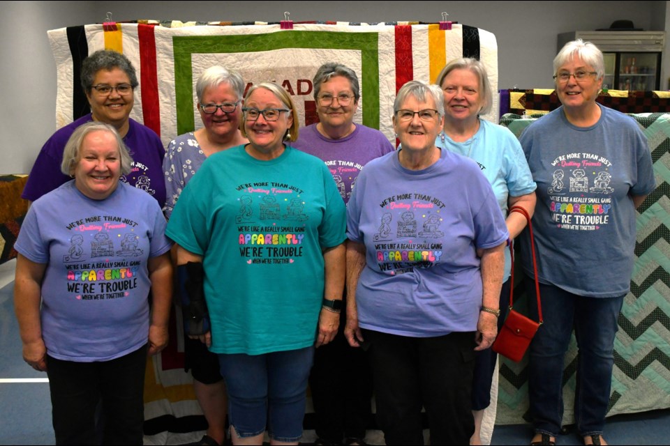 Eight members of the Fun Friday Quilters pose during their annual show at the Timothy Eaton Centre on July 30, proudly sporting new sewing-themed T-shirts. Terri Florkiewicz, one of the group’s founding members, stands back row, left.