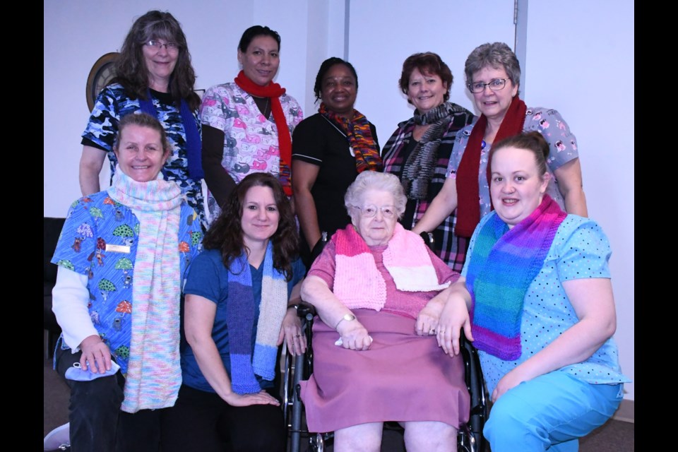 Staff from Chateau St. Michael's care home display the scarves that resident Irene Morrell (front, second from right) created for them. Photo by Jason G. Antonio 