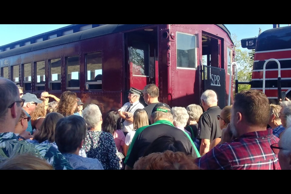 Dale the conductor (centre) welcomes people onto the train. Photo by Jason G. Antonio