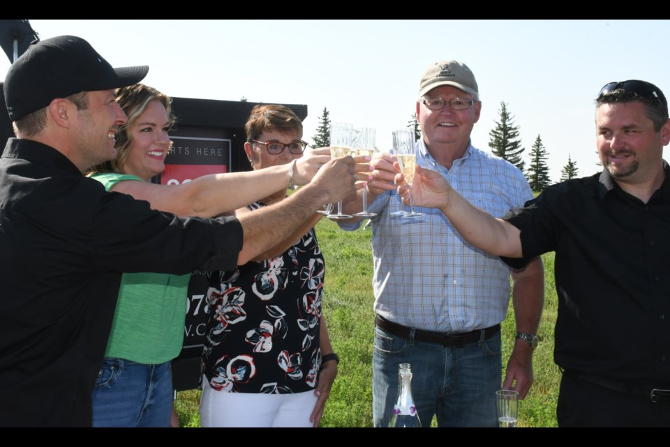Let's celebrate! Alair Homes owner Darius Wilson, Shannon Forrester with Floor Covering International, Joan Clarkee, Mayor Grant Clarke, and Alair project manager Mike Armstrong clink glasses of champagne during a ground-breaking ceremony for a new subdivision on July 9. Photo by Jason G. Antonio 