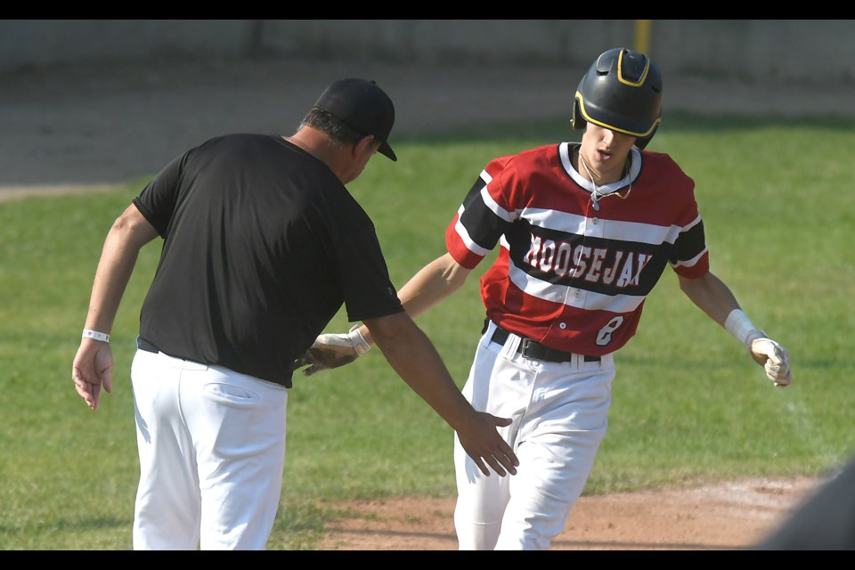 Caleb Newkirk receives congrats from coach Darryl Pisio after hitting a home run against the Sherwood Park Athletics.
