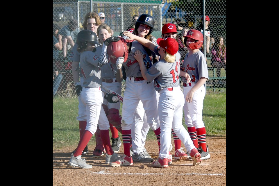 Members of the Canucks swarm Zaid Guillaume after he crosses home plate with his first home run of the game.
