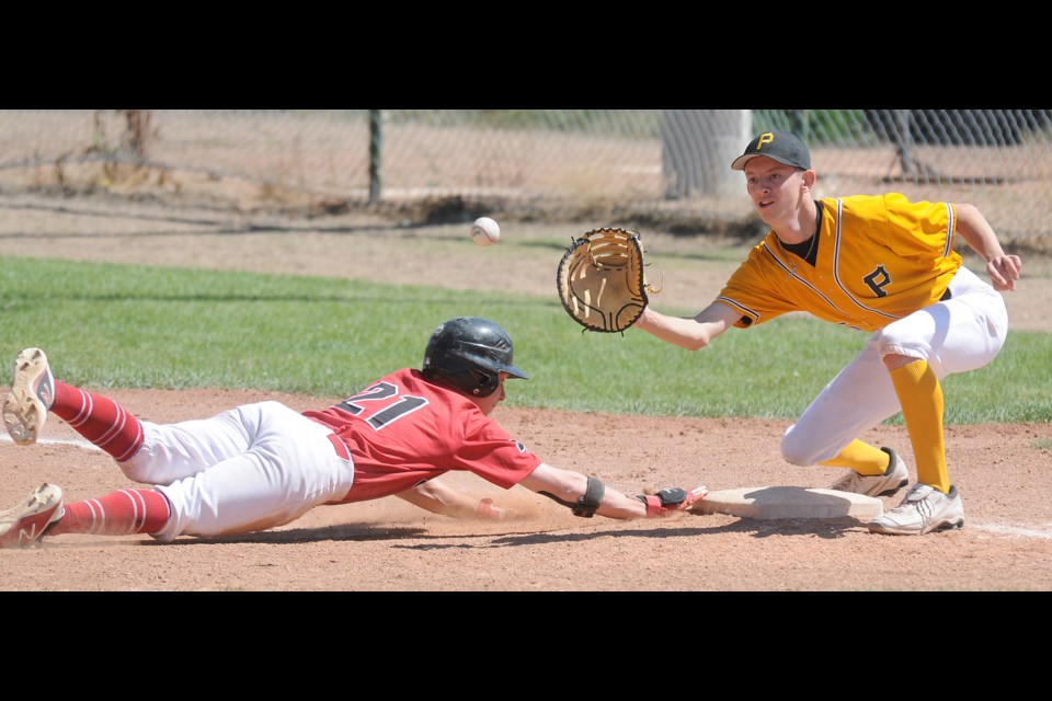 Canucks baserunner Tyler Lorenz dives back into first ahead of the throw from the pitcher.