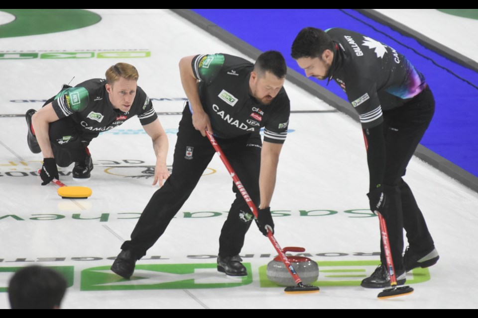 Canada’s Ben Hebert and Brett Gallant sweep a Marc Kennedy shot.
