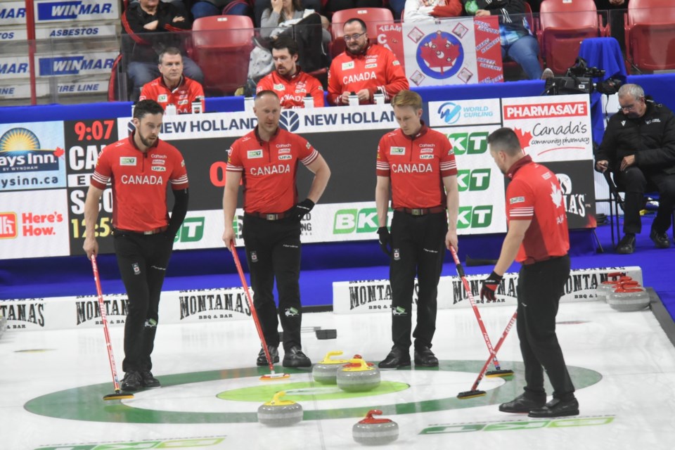 Team Canada discusses strategy in the ninth end against Scotland. 