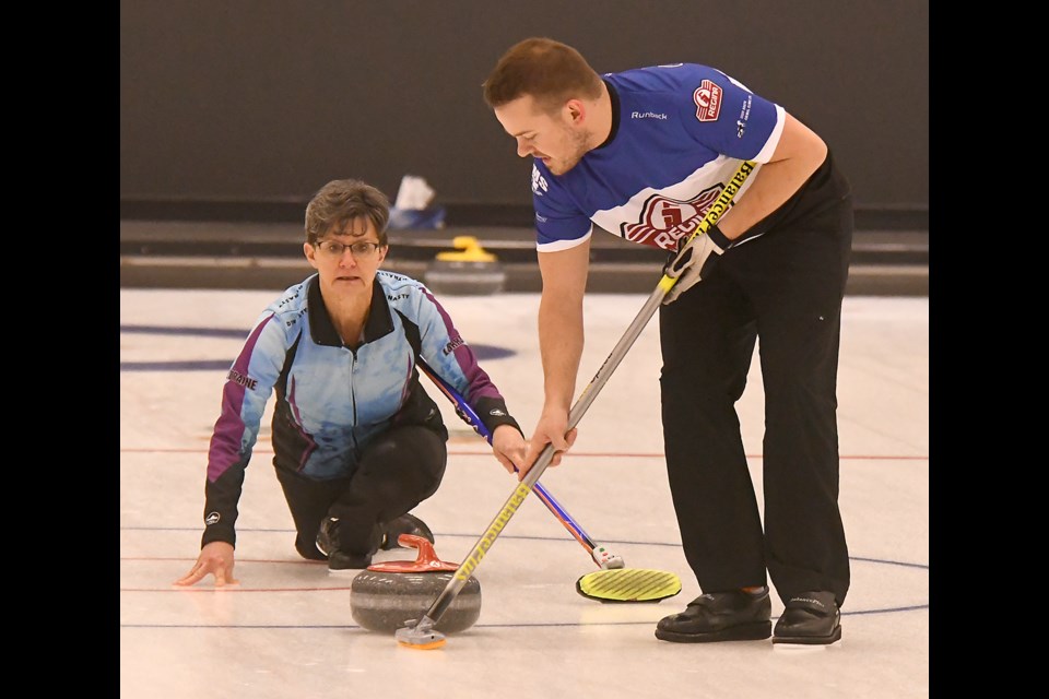 Lorraine Arguin watches the line as Ben Gamble puts broom to ice during the ‘A’ semifinals.