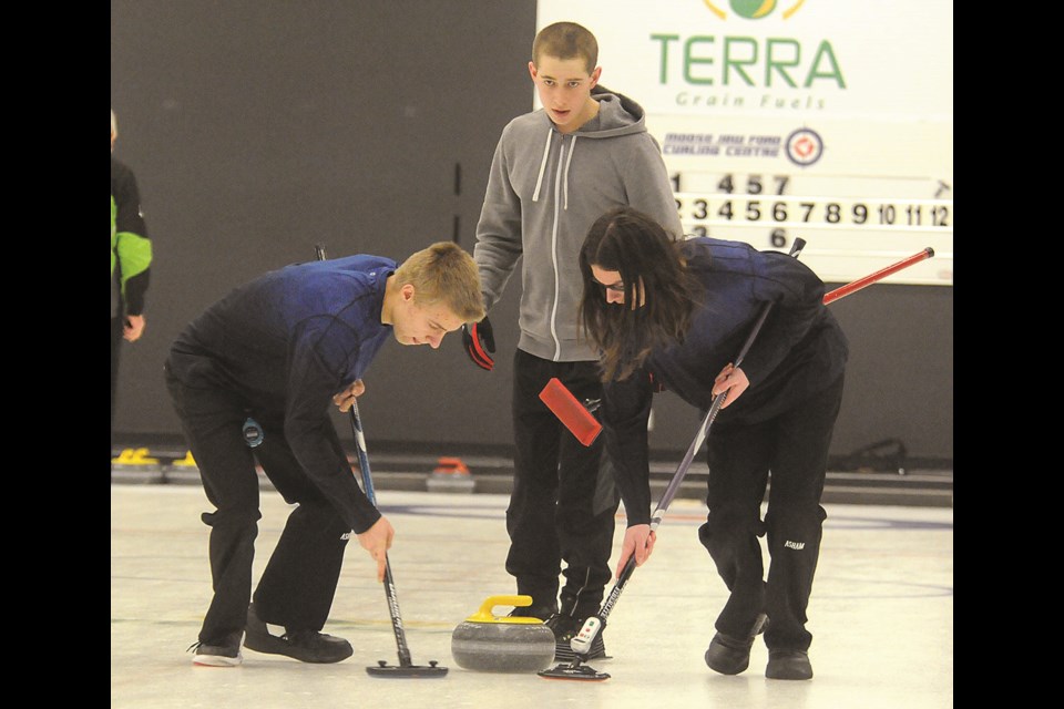 David Gray and Connor Johnson sweep a shot in front of Matthew Swanson during the Moose Jaw Men's Bonspiel 'B' final on Saturday. Randy Palmer photograph