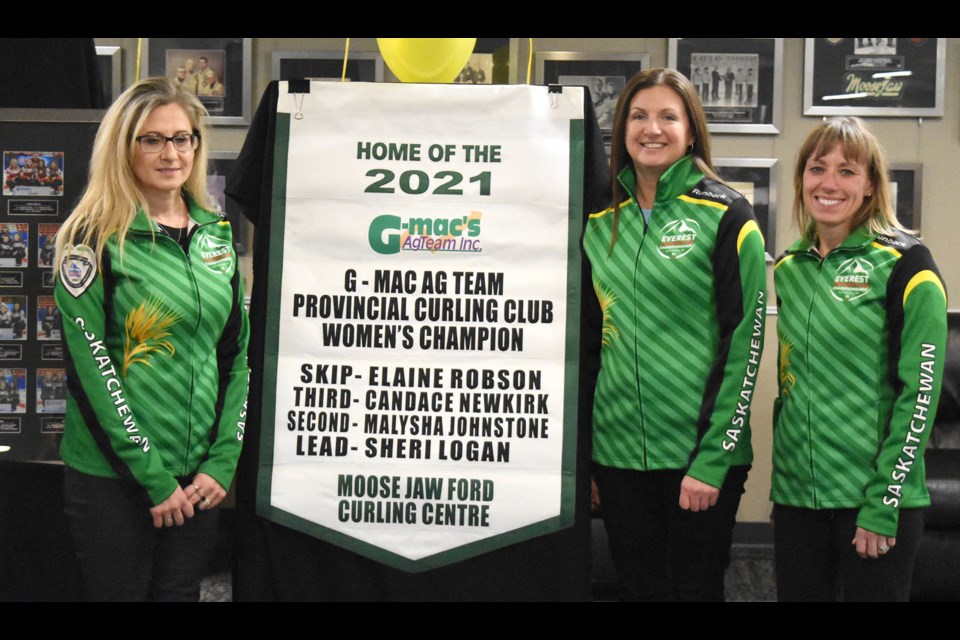 Candace Newkirk, Elaine Robson and Sheri Logan with their 2021 provincial women’s curling club championship banner.