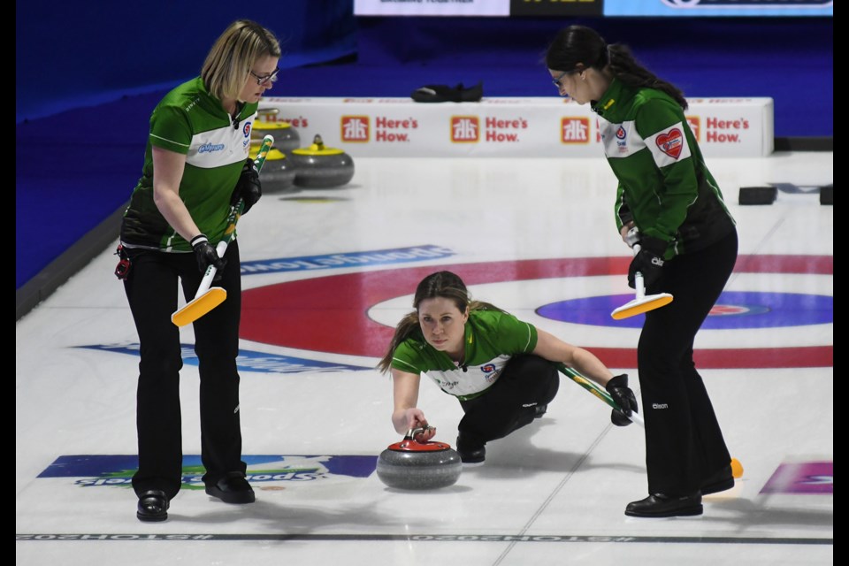 Saskatchewan's Stephanie Schmidt throws as Stefanie Lawton and Kara Thevenot prepare to sweep.