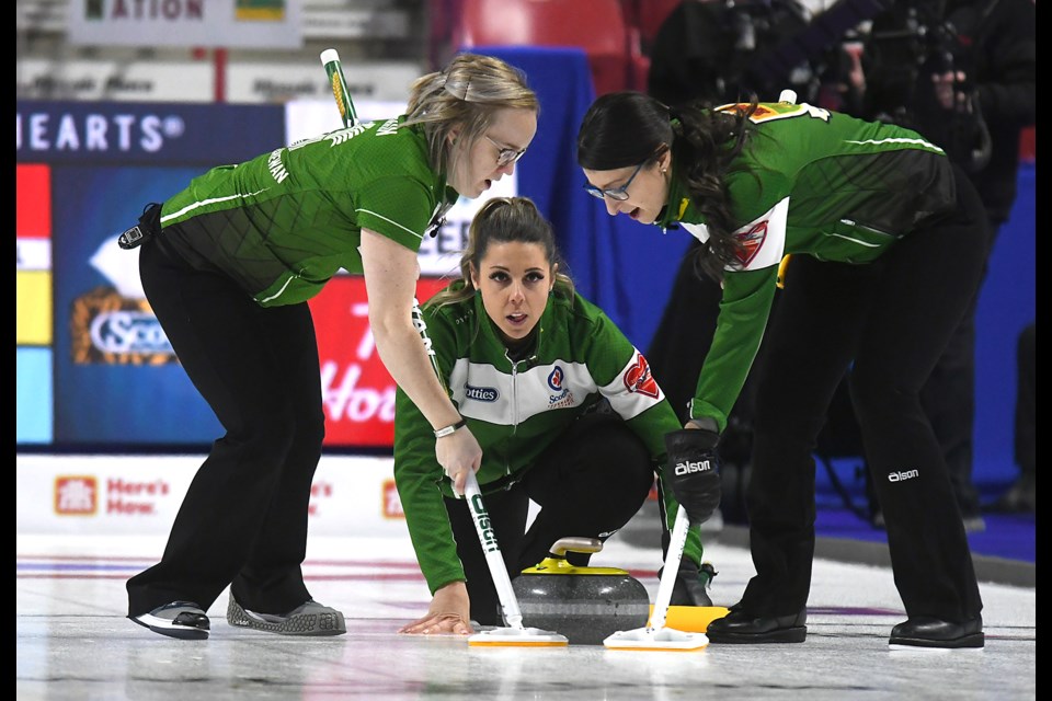 Robyn Silvernagle throws as Jessie Hunkin and Kara Thevenot sweep.