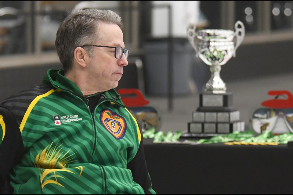 Sask 1 skip Gil Dash keeps an eye on the action with the hardware they were playing for close at hand.