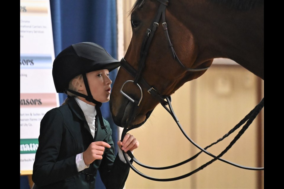 Heartfelt Kiss - Eleven year old Emma Winter of Weyburn, Saskatchewan gives her horse Taco 2 Go while waiting to compete - MJ Independent photo