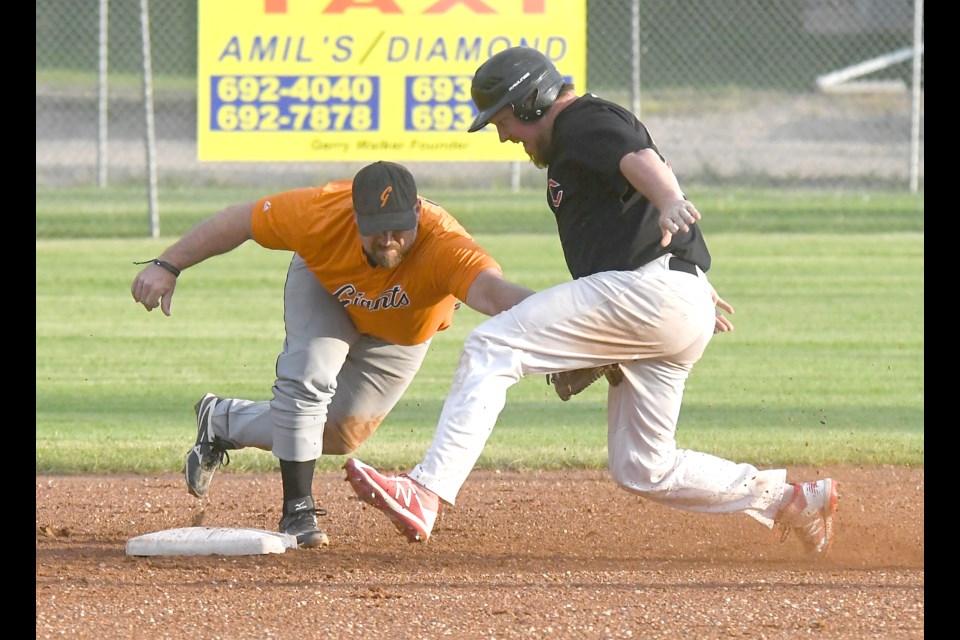 The Giants’ Kevin Knelsen lunges back for the tag at second as the Canadians’ Brad Reaney scrambles to the bag.