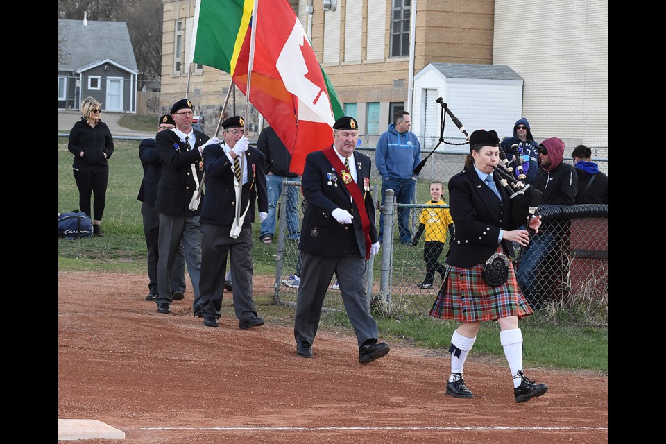 The Legion Colour Guard pipes in the players and coaches to open the Moose Jaw and District Girls Minor Fastball season.
