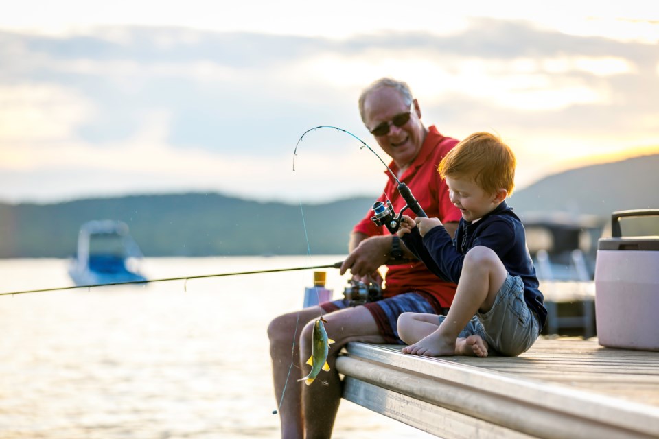 A grandfather and grandson fish together