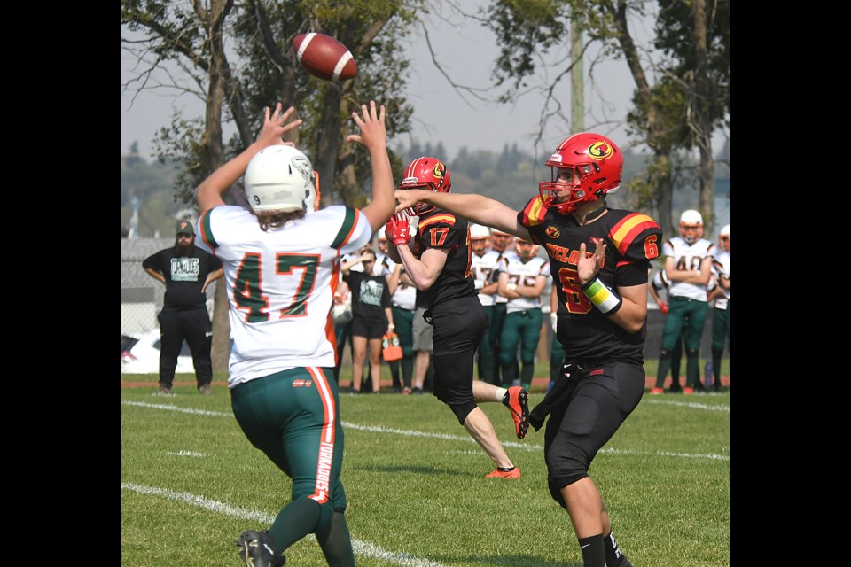 Wil Ansell fires a pass downfield as Malcolm Hunter goes for the bat down.