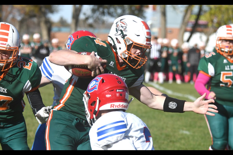Peacock quarterback Owen Varjassy fights through the tackle of a couple of Swift Current defenders.