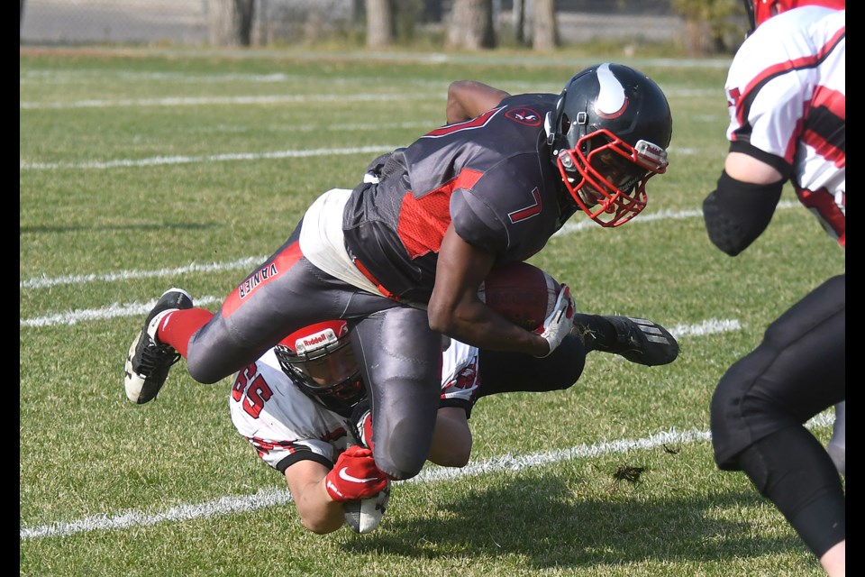 Vanier running back Natan Shiferaw battles for an extra yard or two while being tackled by Weyburn's Alex Junk.