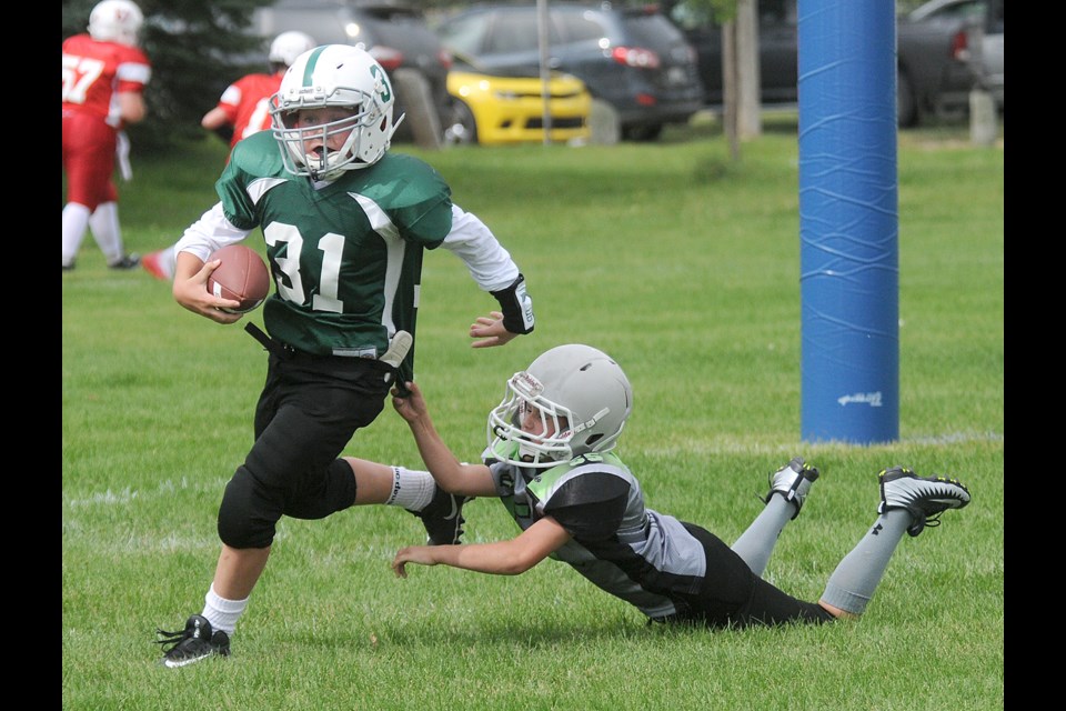 Moose Jaw Minor Football Under-12 action between the Moose Jaw Spartans (dark green) and Estevan Chargers.