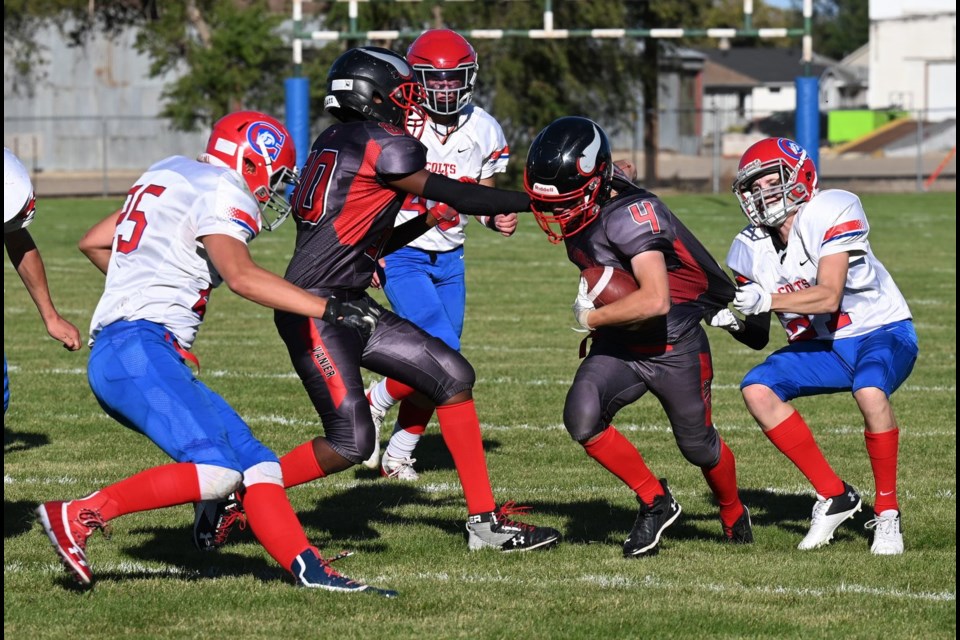 Joe Marak (second from the right) from the Vanier Vikings tries to break a tackle by Parker Latimer from the Swift Current Colts - MJ Independent photo