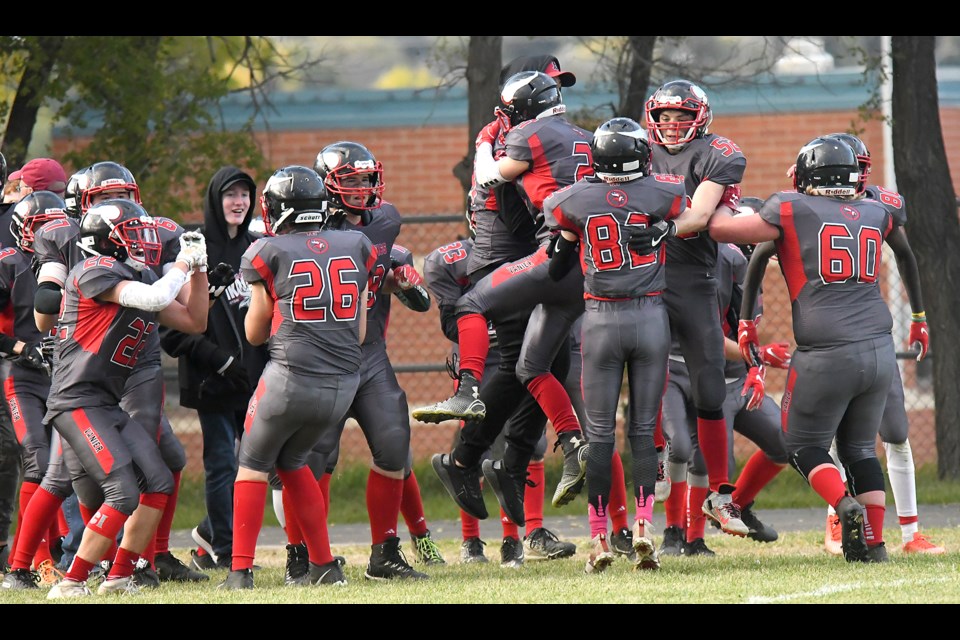 The Vanier Vikings celebrate after their 18-13 victory over the Peacock Tornadoes.