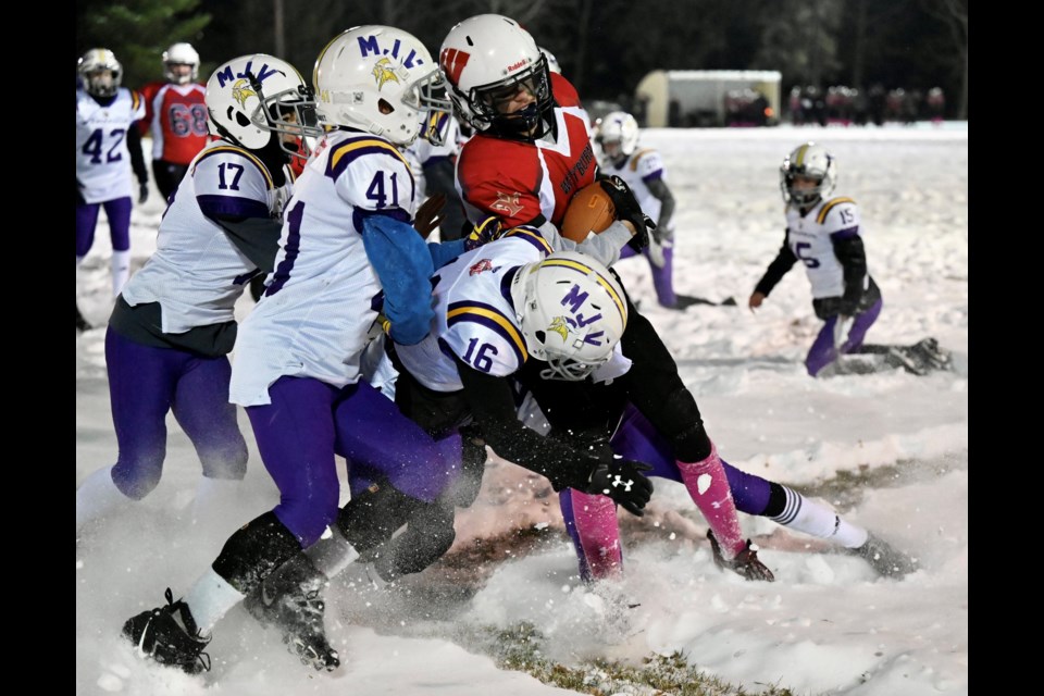 A trio of Moose Jaw Vikings defenders converge on a Weyburn Falcons ball carrier