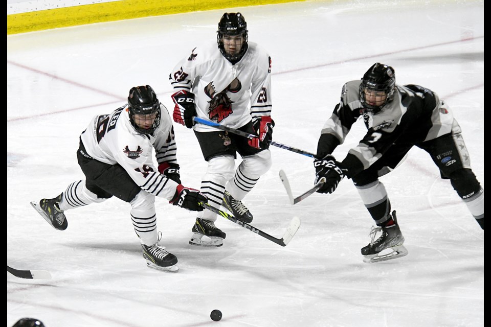 Connor Miller and Jake Briltz duel a Battlefords defender for the puck during third period action.
