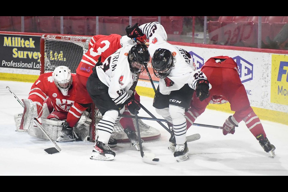 Kayden Ostrom and Jake Briltz battle for the puck at the side of the Notre Dame net.