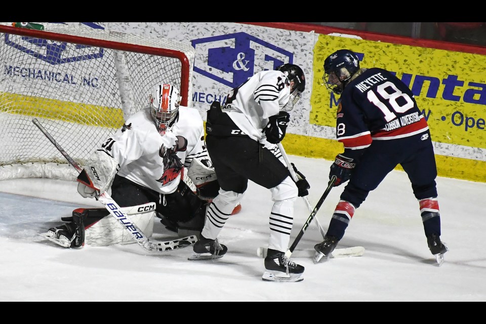 Warriors goaltender Ryan Bain makes a save on Ellis Mieyette in close as Brennan Brown covers the play.