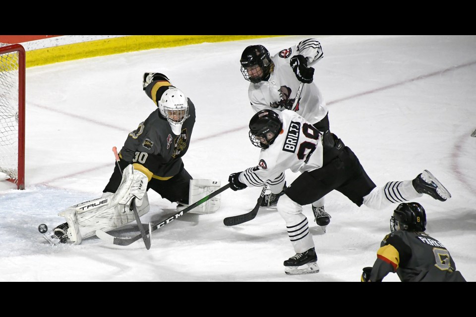 Jake Britlz tucks the puck around Warman goaltender Riley Deck for the Warriors’ fourth goal.