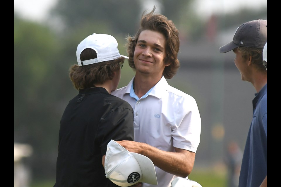 Hunter Kutcher receives congratulations from Royal Regina clubmate Will Blake after winning the junior men’s provincial championship.