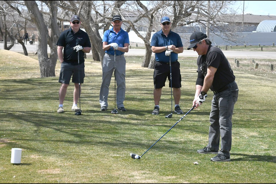 Terry Hardy prepares to tee off as Keith Gieni, Lee Longworth and Jean-Marc Plourde look on during a round at the Lynbrook Golf Course on opening day Friday afternoon.