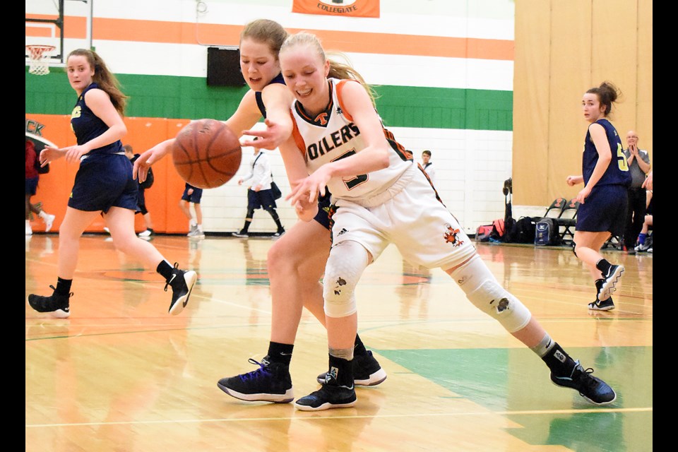 Peacock's Anna Maelde battles Caronport's Emma Carter for the ball during late fourth quarter action.