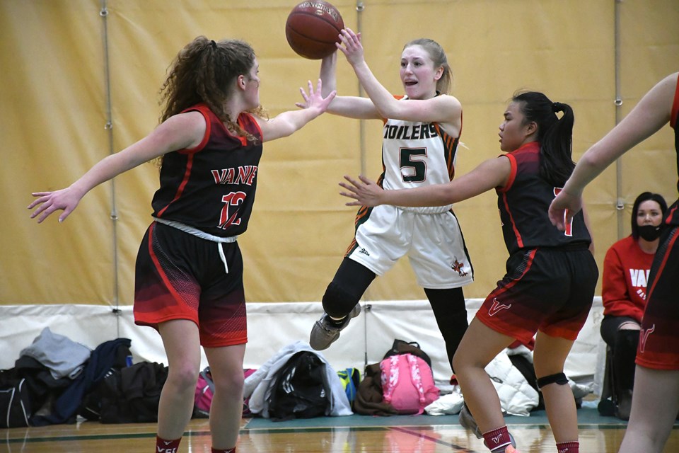 The Toilers’ Ella Muchowski fires a cross-court pass over Vanier’s Kate Waldenberger (12) and Feona Tolentino.