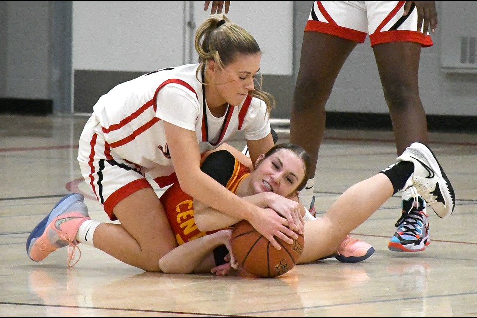 Vanier’s Ava Kindiak and Central’s Rylee Miskiman fight for the ball on the floor.