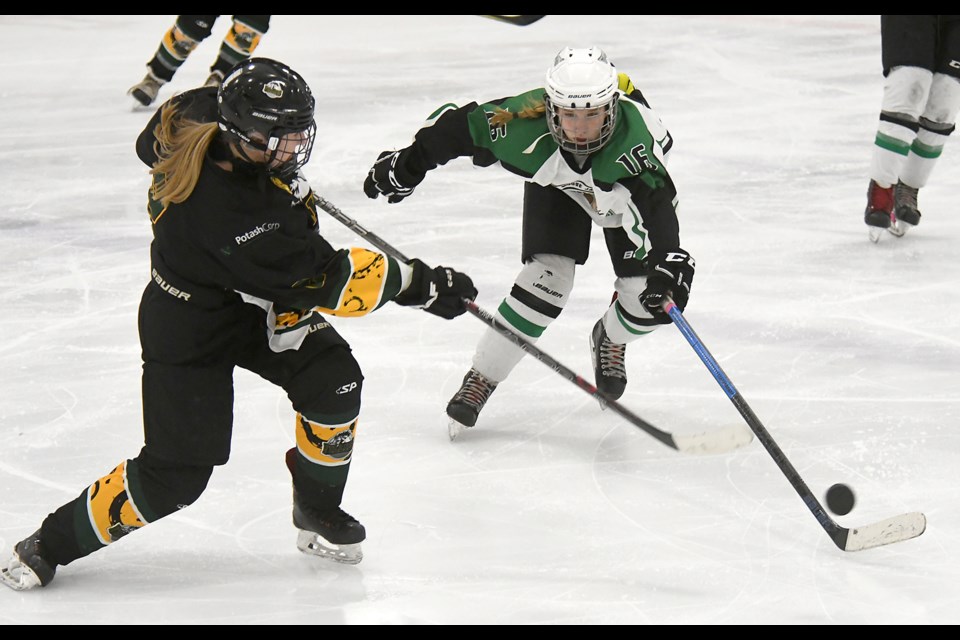 Mavericks forward Ember Dusomme attempts to keep an East Central rearguard from clearing the puck.