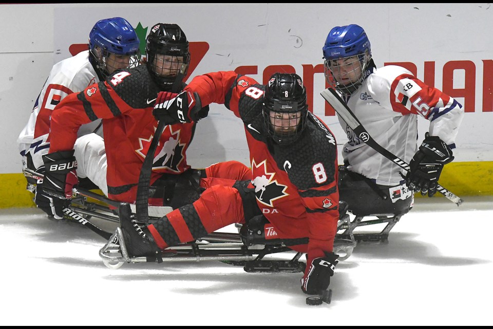 Canada captain Tyler McGregor picks up a puck out of traffic and looks to send a pass to the front of the net.