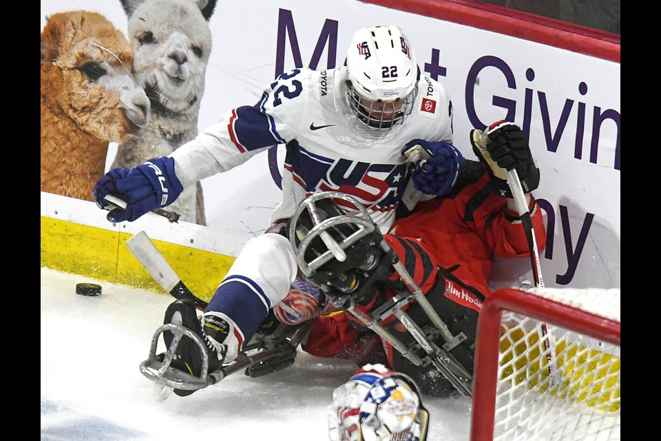 Canada’s Corbyn Smith absorbs a hellacious hit by United States’ Noah Grove. 