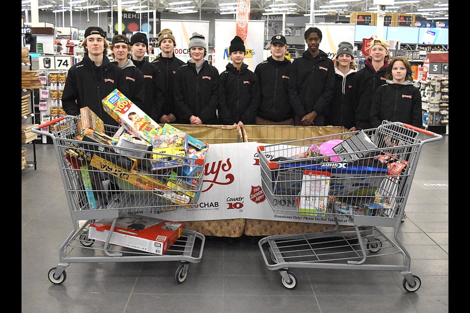The Moose Jaw U15 AA Warriors with a portion of their toy haul on Thursday night.