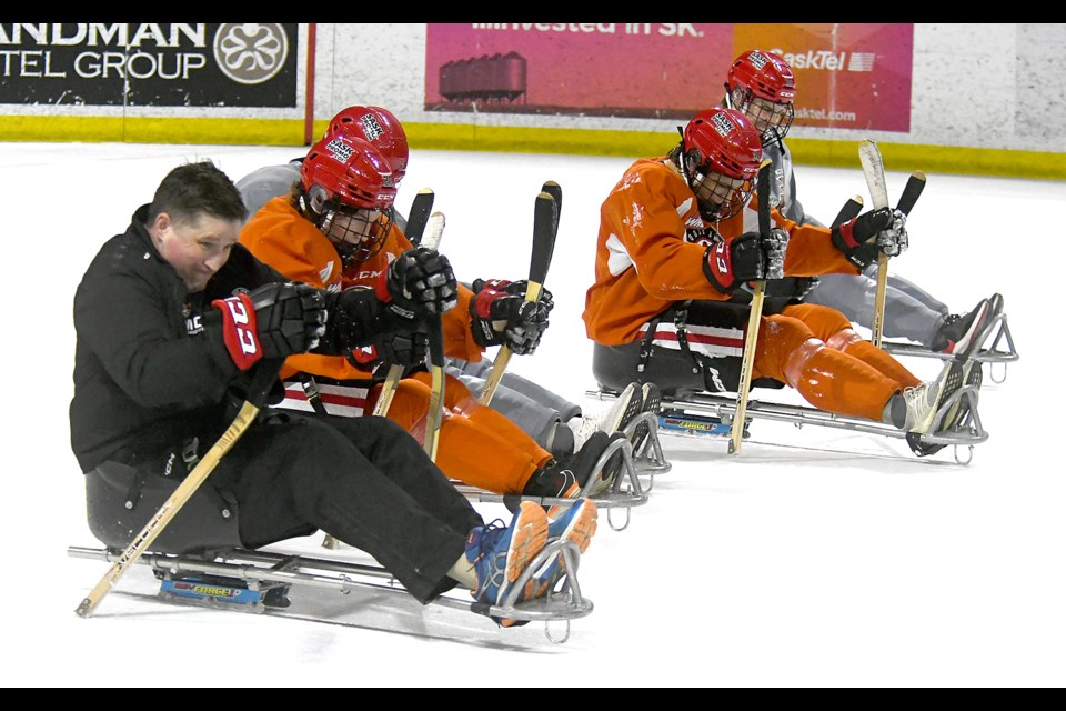 Moose Jaw Warriors assistant coach Gord Burnett takes on players Connor Schmidt, Ethan Hughes, Brady Ness and Owen Berge in a race.