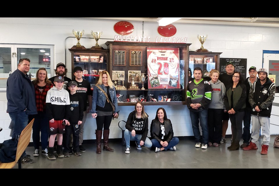 Members of the Moose Jaw Lacrosse Association community gather for a photo around the new display in the Kinsmen Arena.