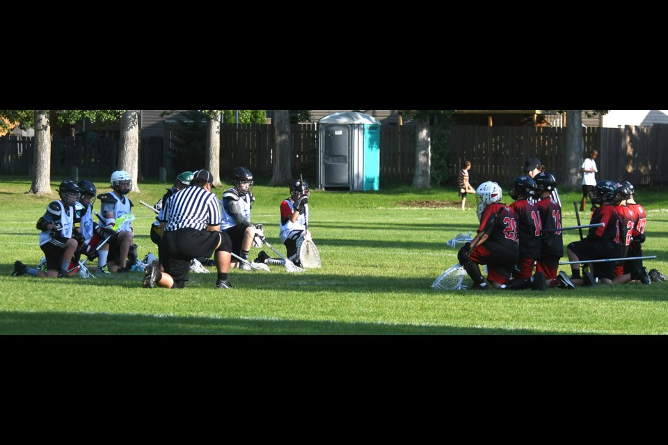 Members of the Moose Jaw Mustangs and Regina Royals take a knee for 30 seconds prior to the contest in in honour of the children who never made it home from residential schools.