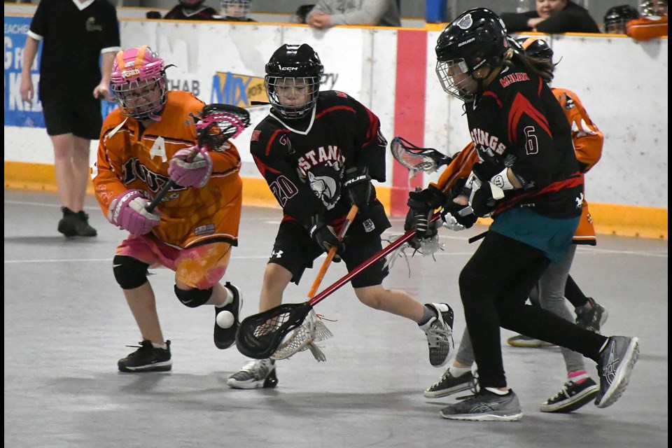 Bennett Dunlop (20) and Arian Louison (6) from the Moose Jaw Mustangs battle a pair of Standing Buffalo defenders for a ground ball.